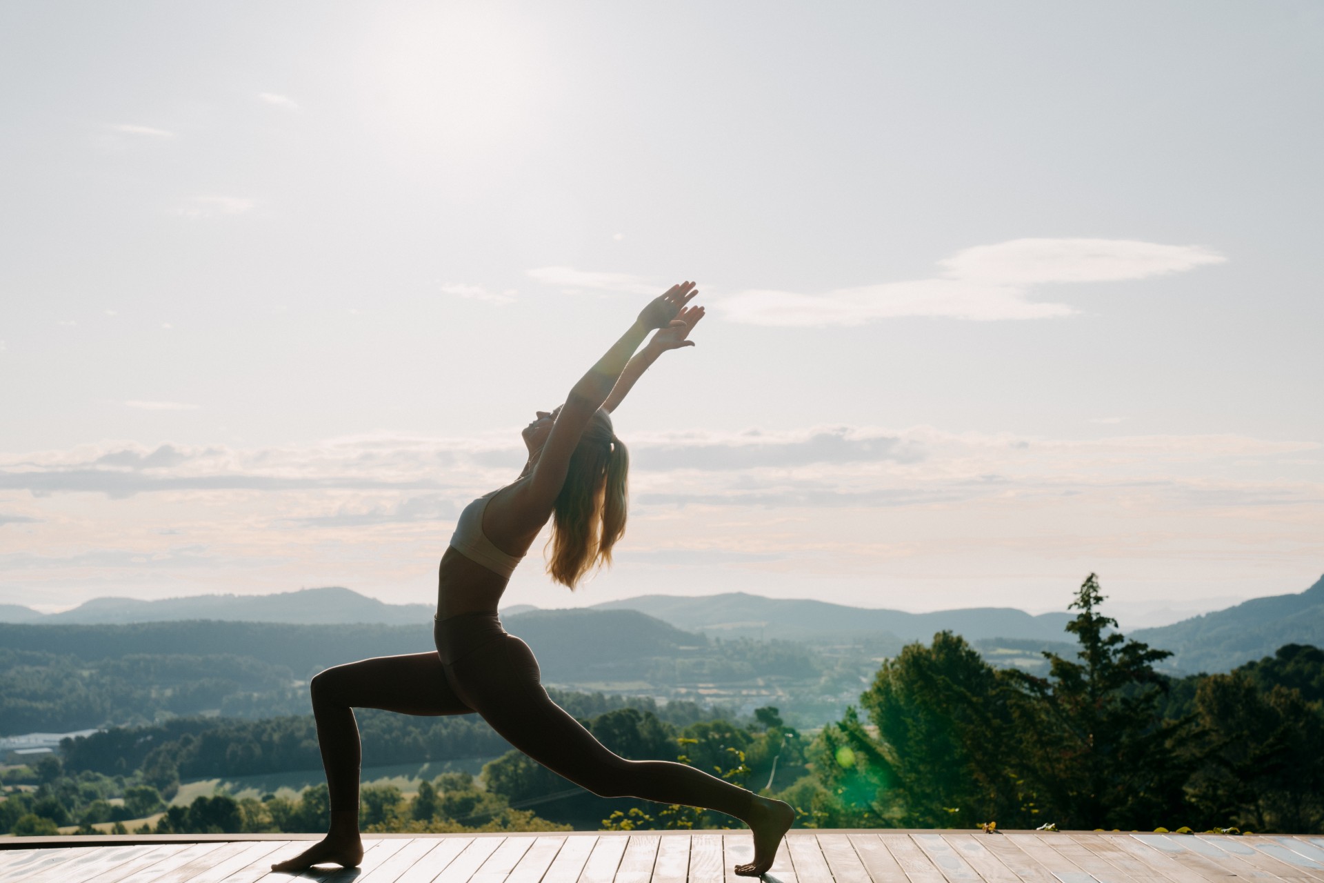 Lina Jurevičiūtė in warrior pose on yoga deck